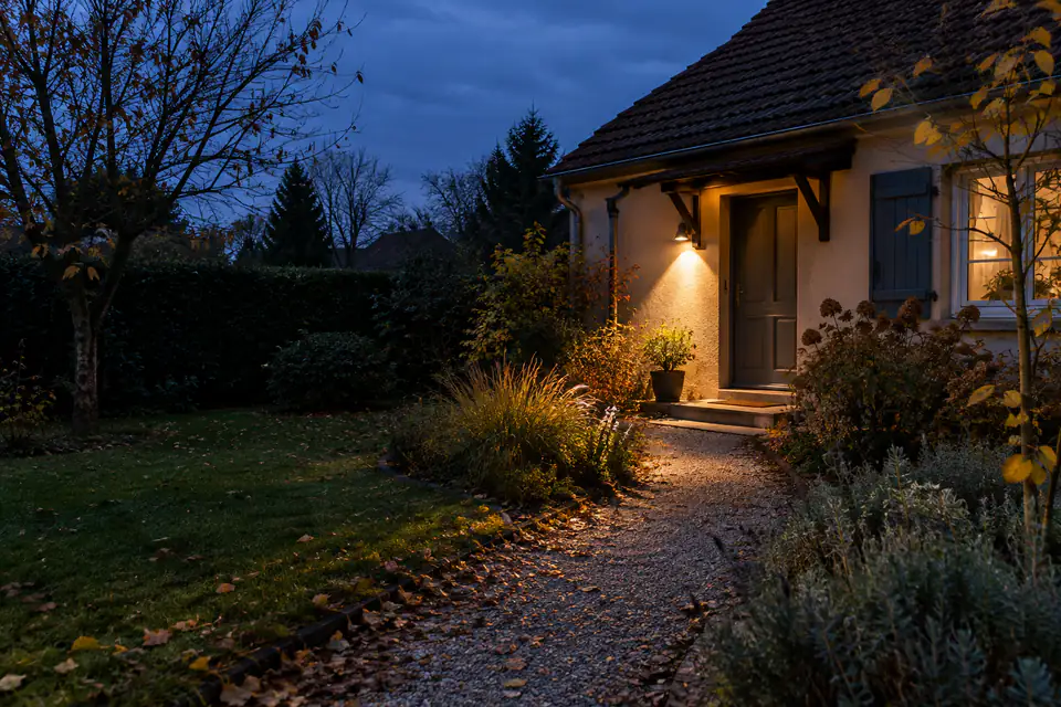 Applique de jardin à lumière chaude éclairant une allée sans diriger son faisceau vers les haies voisines