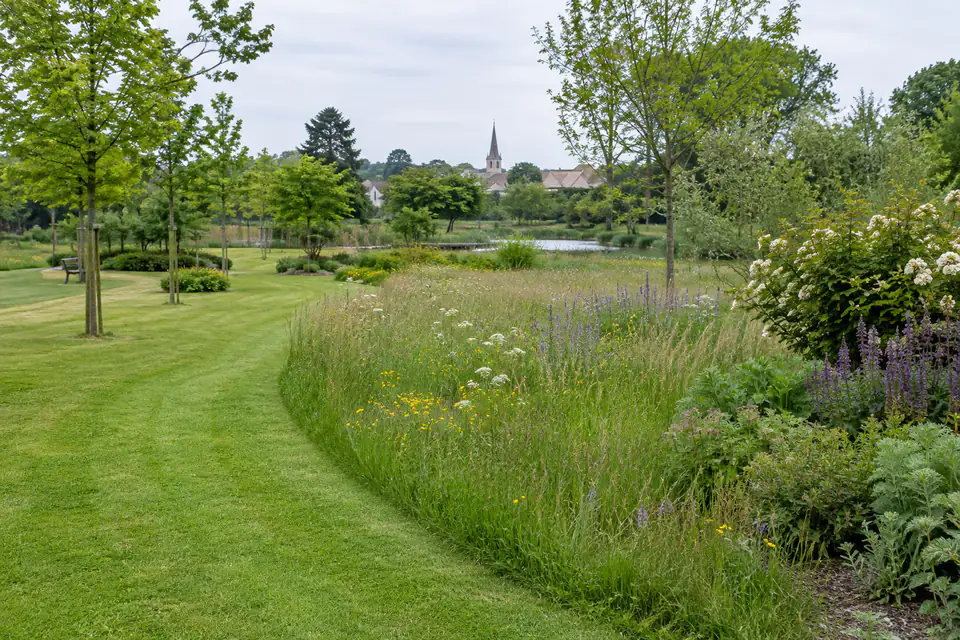 Parc communal associant une bordure tondue, une prairie haute et des plantations diversifiées